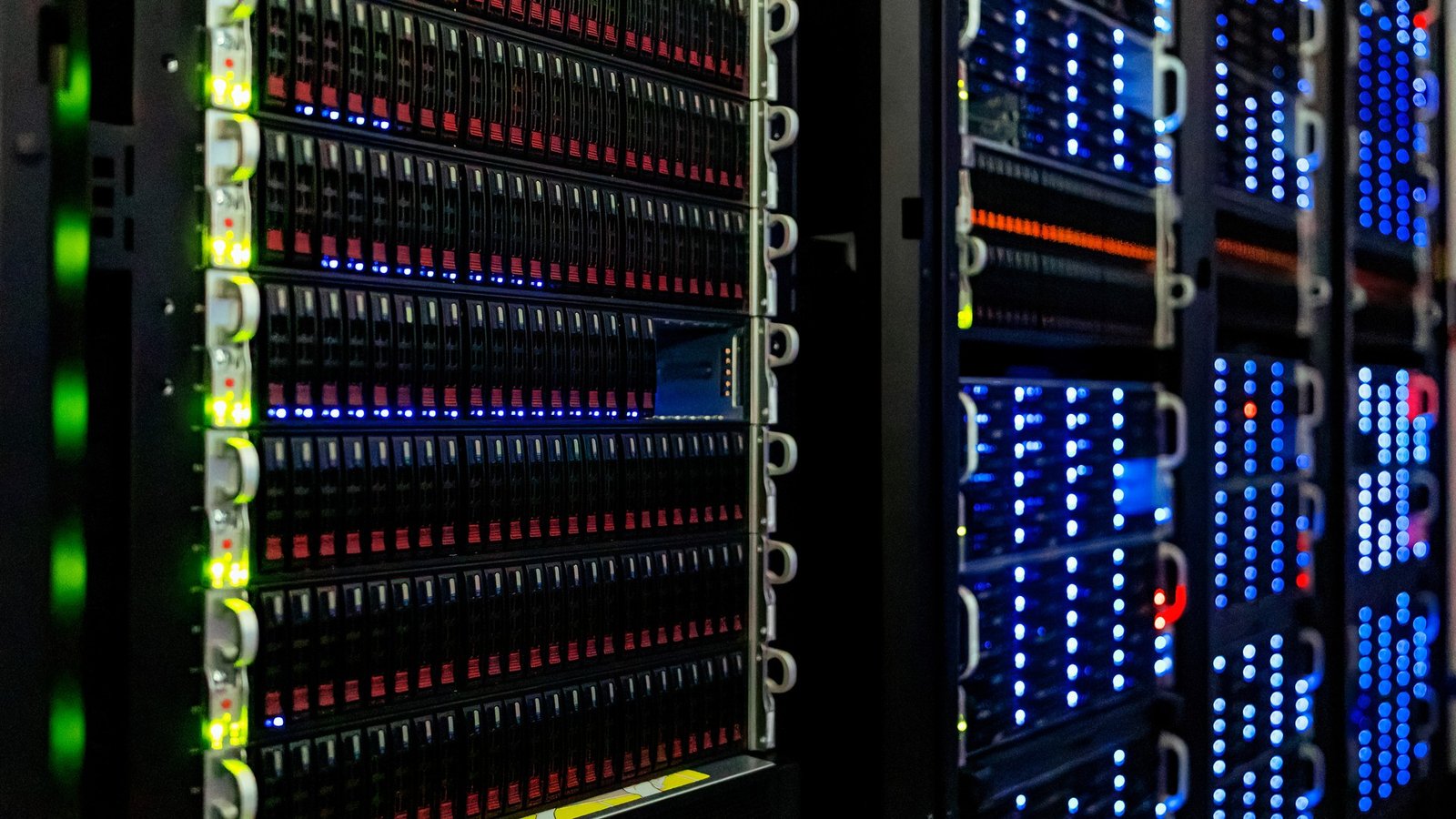 Pasillo de bastidores de servidores en una sala de máquinas: el hardware físico de la nube donde el hipervisor KVM aísla cada máquina virtual invitada