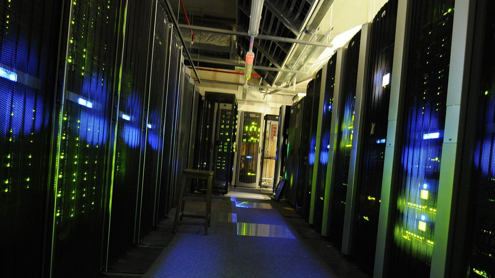 Pasillo de una sala de servidores con racks iluminados en secuencias, imagen del tipo de infraestructura VPS que GMO Internet apagó tras confirmar malware en los entornos de Onamae.com Desktop Cloud